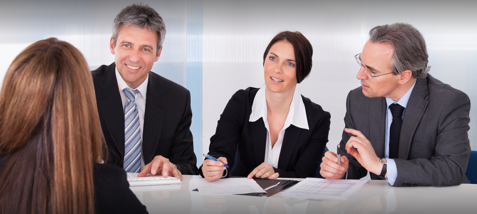 Group Of Businesspeople Interviewing Woman In Office